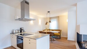Une cuisine moderne dotée d’un îlot central, d’un four encastré et d’appareils électroménagers en acier inoxydable.