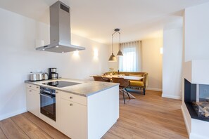 Uma cozinha moderna com ilha, forno embutido e eletrodomésticos de aço inoxidável.