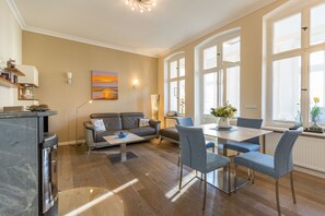Uma sala de estar moderna com sofá, mesa de centro e área de jantar com cadeiras.