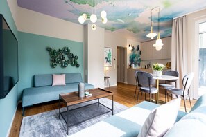 A modern living room with a sofa, coffee table, and dining area.