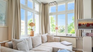 A cozy living room with a large window, a sofa, a coffee table, and a television. - Rolandseck, App. 3, Germany (Heringsdorf)