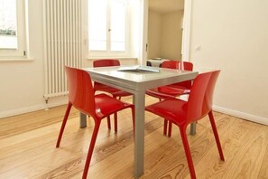 Un comedor con una mesa rectangular y seis sillas rojas.