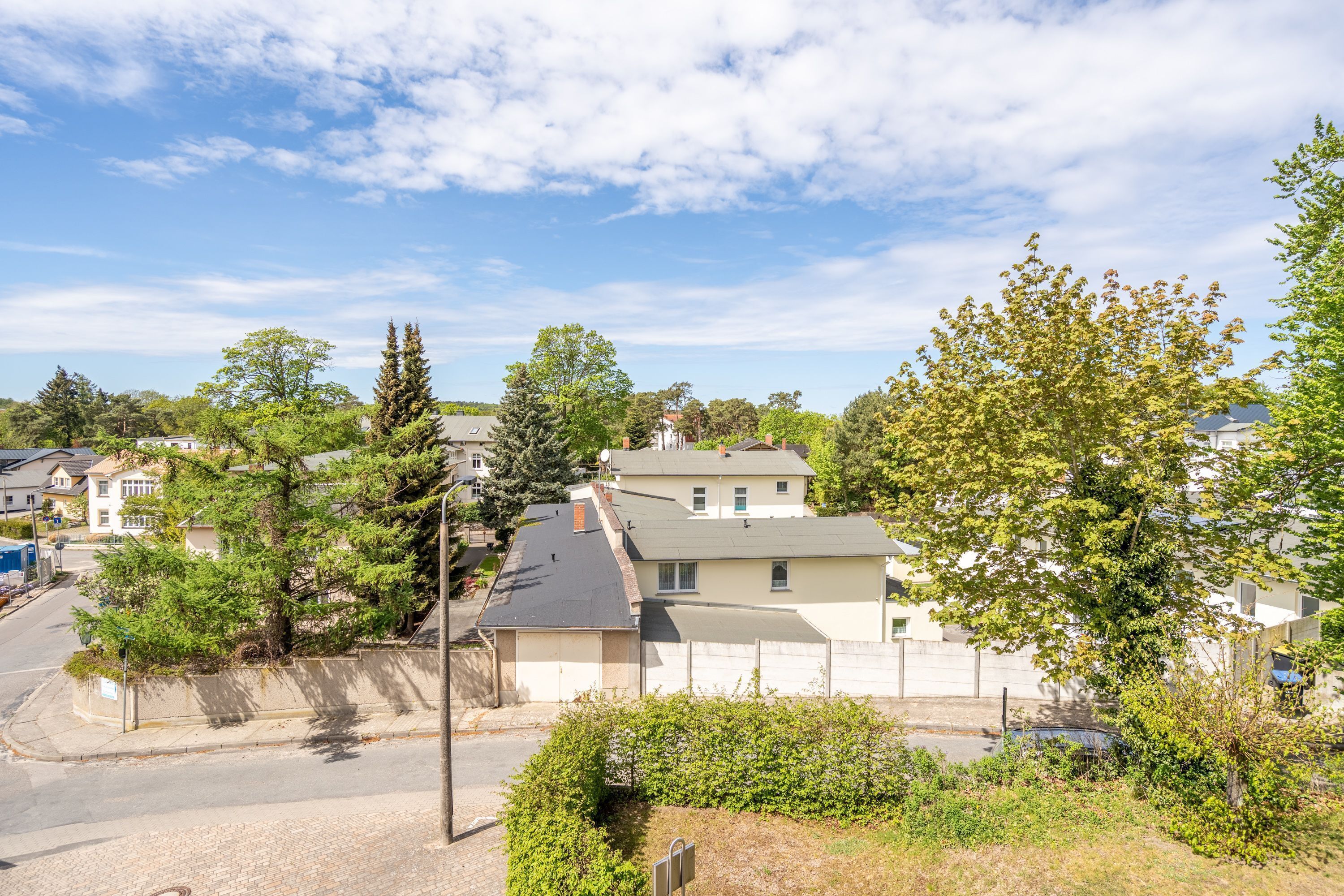 A residential area with houses, trees, and a clear sky.