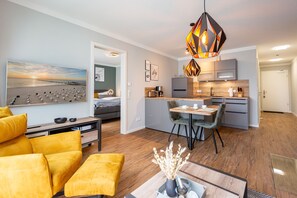 Una sala de estar moderna con un sofá, una mesa de centro y un comedor con sillas y una mesa.