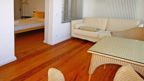 Una habitación con una cama, un sofá y una mesa de vidrio.