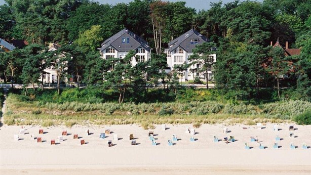 A beachfront property with multiple houses, a sandy beach, and dense greenery. - Villa Strandperle, App. 32a (Heringsdorf)