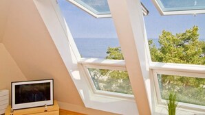 A room with skylights, a television, and a view of the sea. - Villa Strandperle, App. 32a (Heringsdorf)