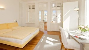 Ein helles Schlafzimmer mit einem Bett, einem Schreibtisch und einem Stuhl.