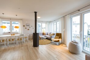 A modern living room with a sofa, a coffee table, and a large window. - Quartier Arinja, App. 01 (Heringsdorf)