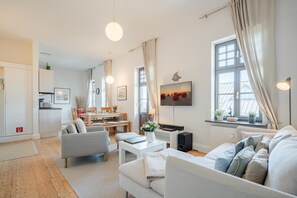 Ein modernes Wohnzimmer mit einer Couch, einem Essbereich und einer Küche.