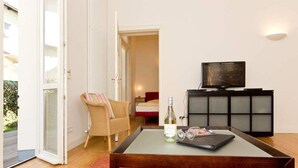 Un salon comprenant un canapé, une table basse, un téléviseur et un meuble.