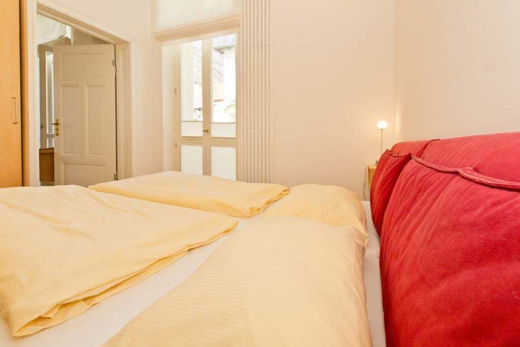 Une chambre d’hôtel avec deux lits, l’un avec une literie jaune et l’autre avec une literie rouge.