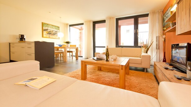 A modern hotel room with a living area, a dining area, and a kitchenette. - Quartier 47, App. 05 (Heringsdorf)