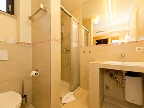 Un baño con inodoro, ducha y lavamanos.
