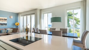 Una cucina moderna con isola centrale, ampie finestre e vista sull'esterno.