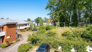 Un quartier résidentiel avec des immeubles modernes, une allée pavée et une voiture garée devant.