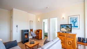 Un salon comprenant un canapé, un téléviseur, une cheminée et un meuble.