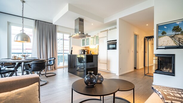 A modern living room with a round coffee table, a sofa, and a dining area with a table and chairs.