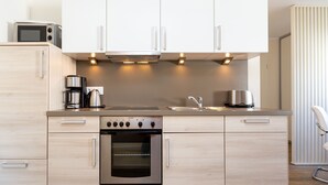 Una cucina moderna con forno integrato, macchina del caffè e microonde.