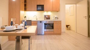 Een moderne keuken met houten kastjes, een ingebouwde magnetron, een vaatwasser en een oven.