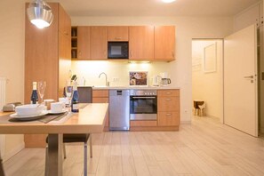 Eine moderne Küche mit Holzausstattung, einer integrierten Mikrowelle, einem Geschirrspüler und einem Backofen.