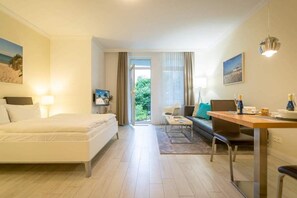 Ein modernes Hotelzimmer mit einem Bett, einem Schreibtisch, einem Stuhl und Blick ins Freie.