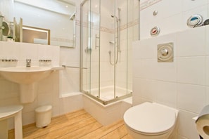 Ein Badezimmer mit Duschkabine, Waschbecken und Toilette.