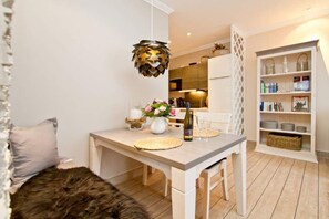 Una cocina moderna con una mesa de comedor, una lámpara colgante y una estantería.