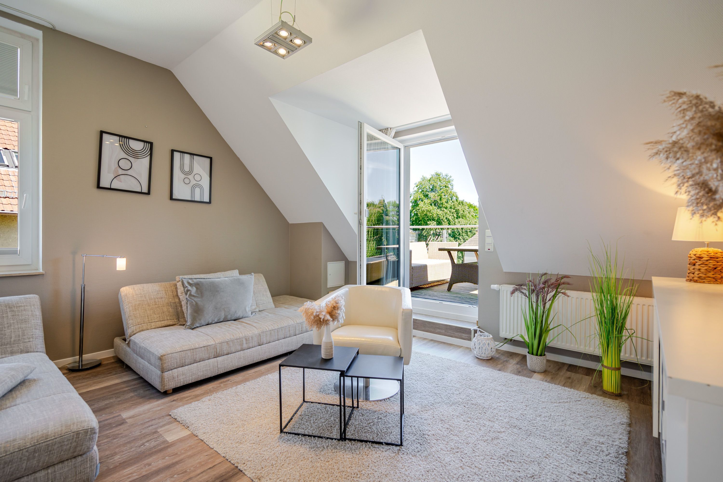 En moderne stue med sofa, sofabord og et kunstværk på væggen.