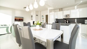 A modern kitchen with white cabinets, a microwave, and a coffee maker.