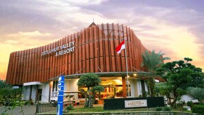 The exterior of Jatiluhur Valley & Resort with a modern design, a flag, and a sign indicating 'CRHAVIDYA JATILUHUR'. - Jatiluhur Hotel Valley & Resort (Purwakarta)