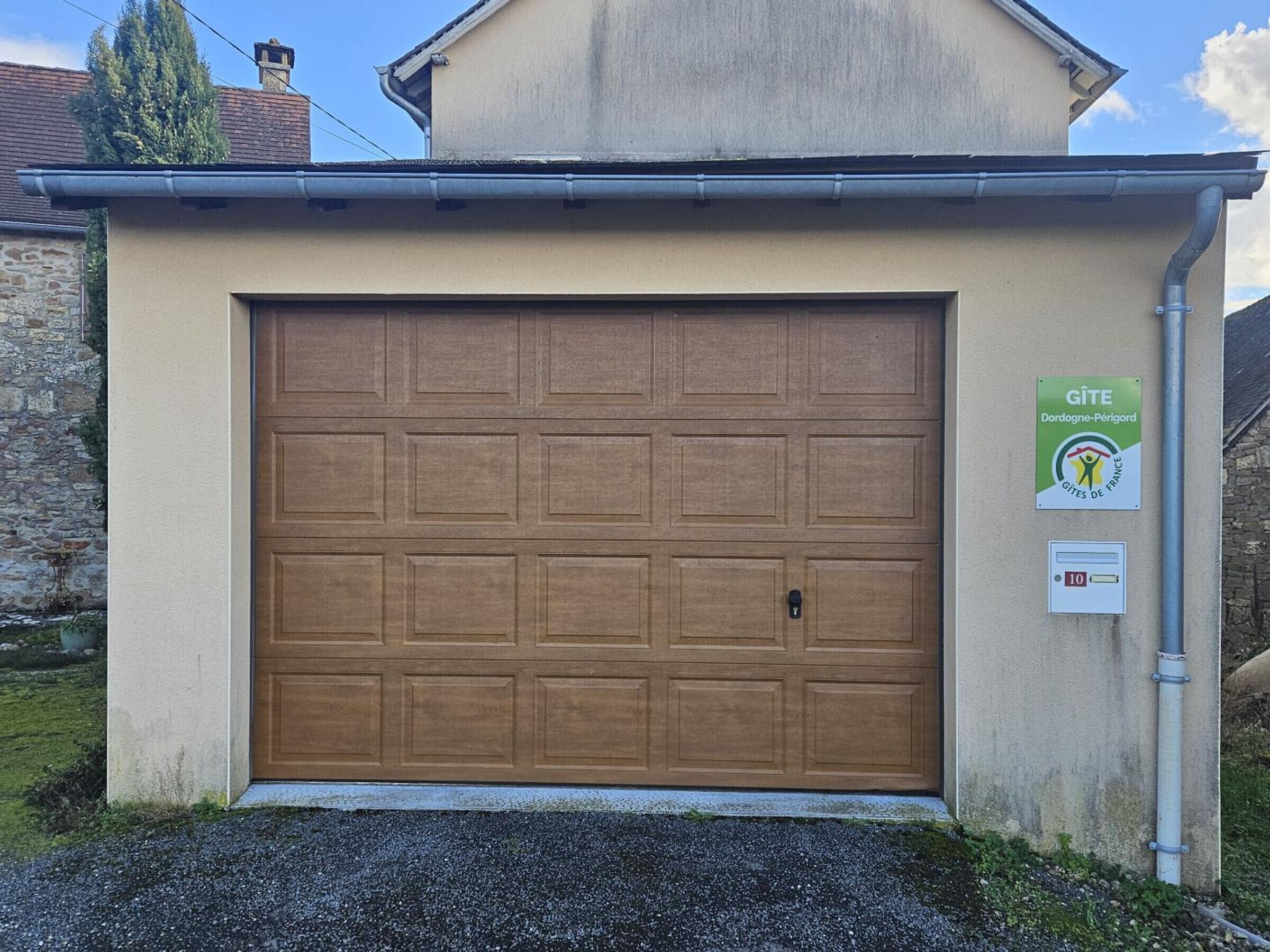 A garage door with a sign indicating it is a Gîte in Dordogne-Périgord, France.