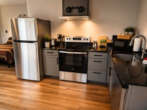Una cocina moderna con electrodomésticos de acero inoxidable, horno empotrado y microondas.