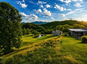 Uma casa com lago, cercada por vegetação exuberante e colinas.