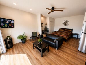 A modern living room with a sofa, coffee table, and a TV mounted on the wall.