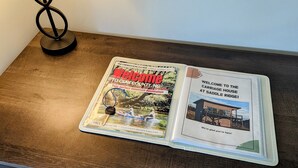 Una revista sobre una mesa de madera con una lámpara a un lado.