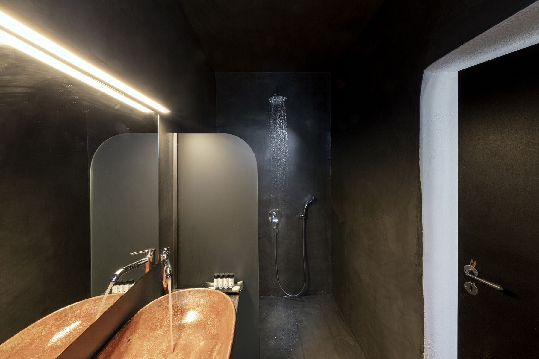 Un baño moderno con un espejo grande, un lavabo y una ducha.