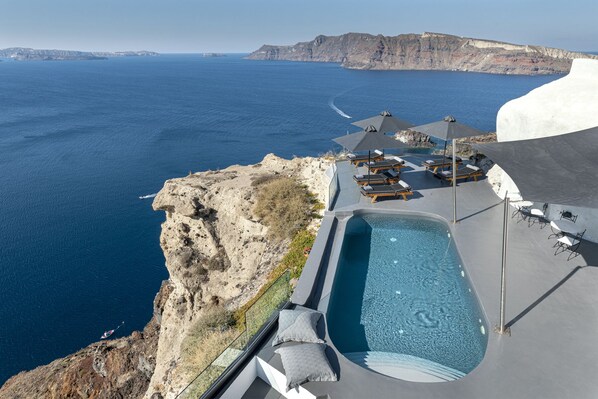 Una piscina al aire libre de temporada, sombrillas