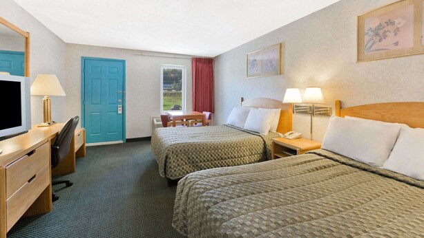 A hotel room with two beds, a desk with a chair, a TV, and a window with a view. - Night Lodge Pocono/bartonsville (Bartonsville)