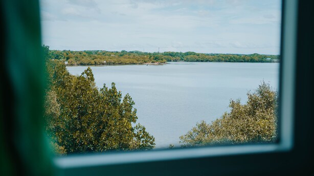 A view of a lake with trees in the foreground and a distant shoreline. - 4k's Pension House by Cocotel (Bogo)