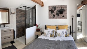 A bedroom with a bed, a bedside table, a mirror, a world map, a wardrobe, and a shower area. - SUPERB VILLA 80 m2 in DUPLEX, 6 pers, 3 bedrooms, 2 bathrooms + garage and garden (Agde)