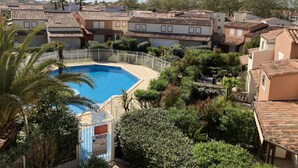 A residential area with a swimming pool surrounded by lush greenery and terracotta-roofed houses. - SUPERB VILLA 80 m2 in DUPLEX, 6 pers, 3 bedrooms, 2 bathrooms + garage and garden (Agde)