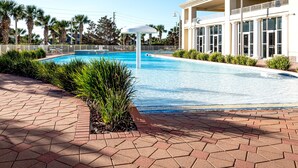 A swimming pool with a white canopy, surrounded by a brick walkway and palm trees. - Ariel Dunes I 508 * Beachy* Modern* 3 pools* (Miramar Beach)