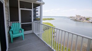 A balcony with a view of a calm body of water and a distant shoreline.