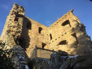 An ancient stone building with multiple arched openings and a wooden railing in front. - Stylish 3-bed Cottage Located in the Cairngorms (Ballindalloch)