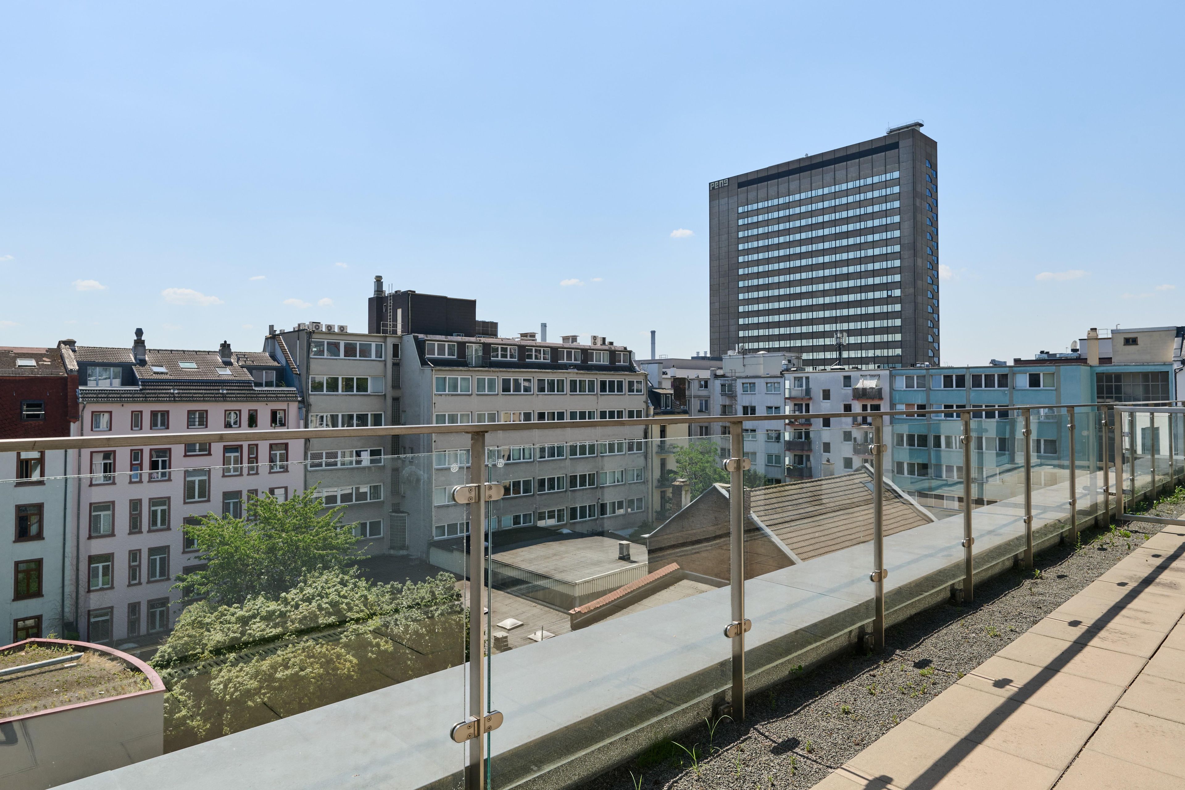 Un edificio de gran altura con un diseño arquitectónico moderno, rodeado de otros edificios con diversos estilos arquitectónicos.