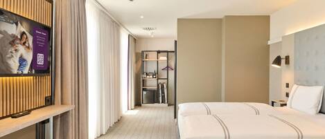 A hotel room with a bed, a TV, a wardrobe, and a bathroom.