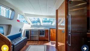 A compact galley with a refrigerator, a seating area, and a view through the windows. - Luxury Italian Megayacht (Fajardo)