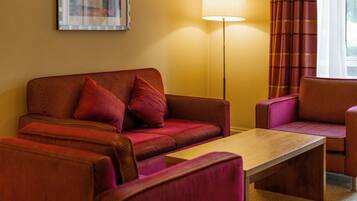 A room with a sofa, a chair, and a table.