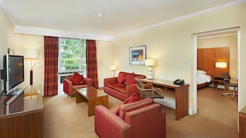 A hotel room with a TV, a desk, a sofa, and a bed.